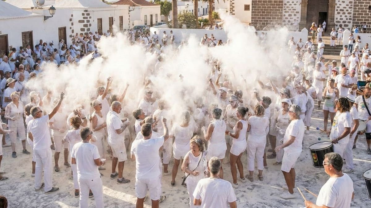 Multitud vestida de blanco celebrando la Fiesta de los Polvos Talco en Tetir, con una nube de talco en la plaza.