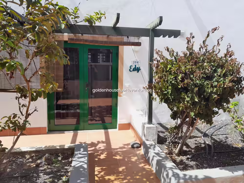 Puerta de entrada verde con placa identificativa del Apartamento Edy en Fuerteventura.
