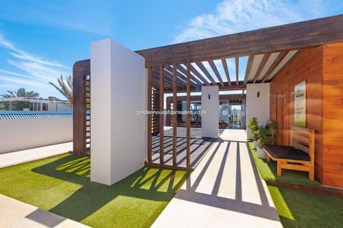 Entrada a un apartamento con una columna blanca.