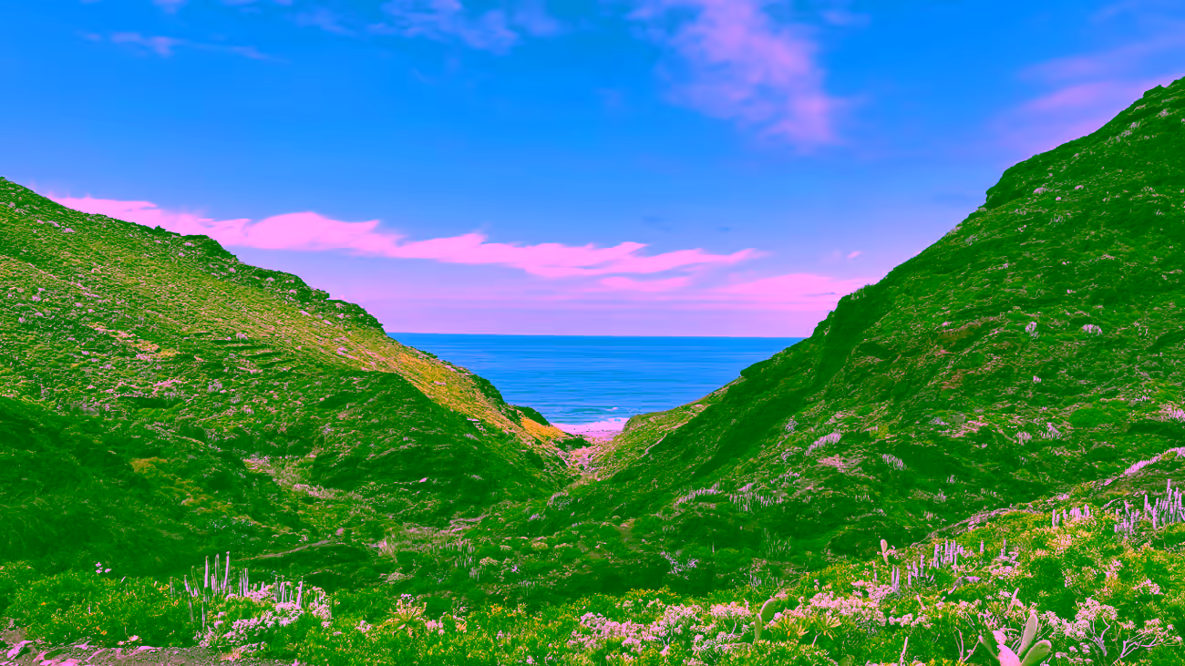 Sendero entre montañas verdes con vistas al océano Atlántico en las Islas Canarias.