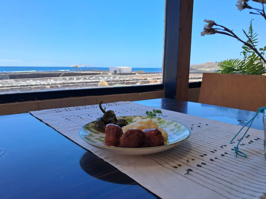 Plato servido en la terraza de Aroma de Sal con vistas a las Salinas del Carmen y al océano Atlántico en Fuerteventura.