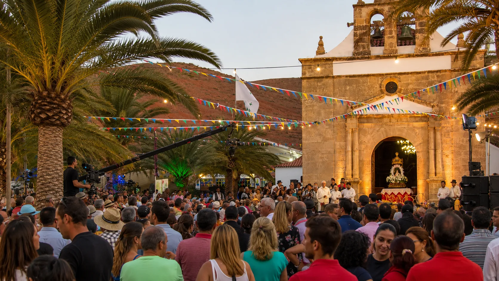 Peregrinos y fieles congregados frente a la Ermita de la Virgen de la Peña iluminada y decorada con guirnaldas durante la Romería de La Peña en Vega de Río Palmas, Fuerteventura.