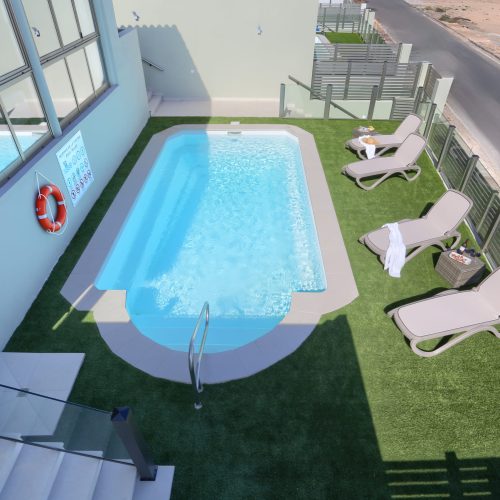 Vista superior de la piscina privada y solárium con hamacas en la Villa Ocean Pacific, Caleta de Fuste