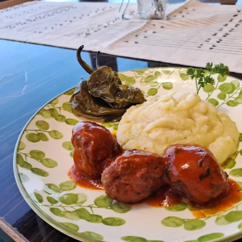 Plato casero de albóndigas en salsa de tomate con puré de patatas y pimiento verde asado en Aroma de Sal.