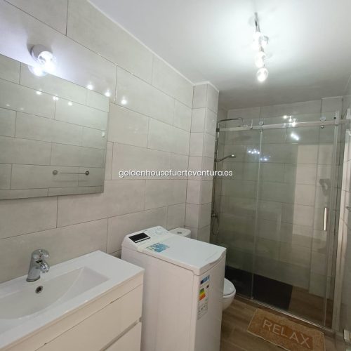 Baño con ducha y lavadora en AP 0046 OCEAN DREAM