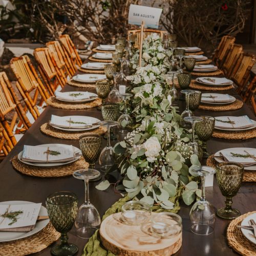 Mesa larga al aire libre decorada con centro de flores en banquete de La Puipana