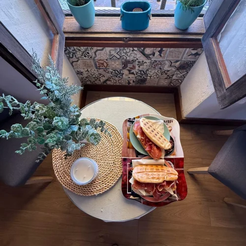Dos apetitosos bocadillos de jamón serrano y queso recién preparados para el desayuno en Aroma de Sal.