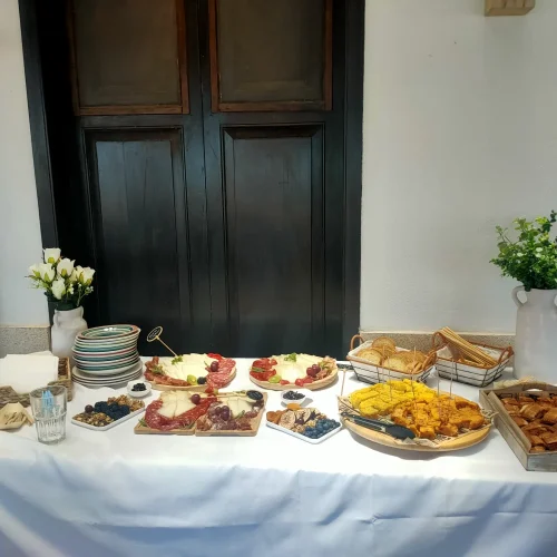 Mesa de buffet con variadas tablas de quesos, embutidos, tortilla y aperitivos preparada para un evento en el restaurante Aroma de Sal.