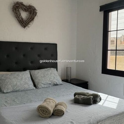 Habitación luminosa con cama de matrimonio.