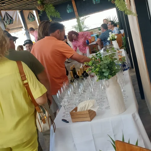 Grupo de invitados disfrutando de un buffet y bebidas durante la celebración de un evento en la terraza del restaurante Aroma de Sal.