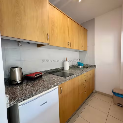 Cocina con muebles de madera y encimera de granito en Fuerteventura.