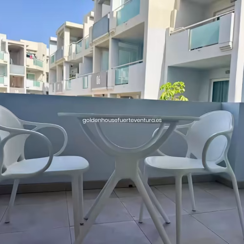 Terraza privada con mesa y sillas blancas modernas en el complejo Corralejo Sun.
