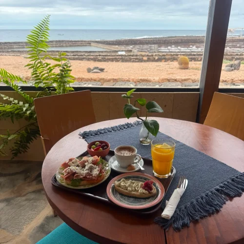 Completo desayuno servido en la terraza del restaurante Aroma de Sal, con impresionantes vistas a las Salinas del Carmen y al océano en Fuerteventura.