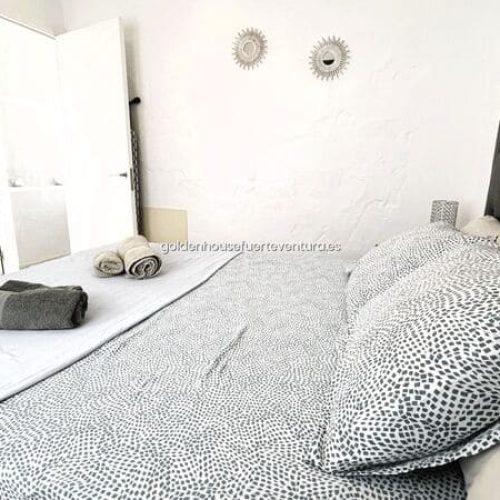 Cama con toallas de cortesía y cojines.