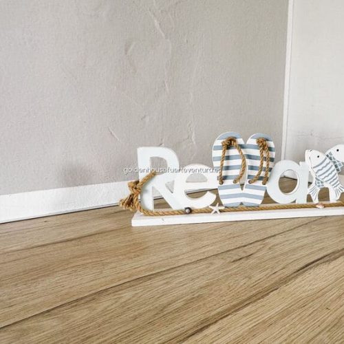 Estante decorativo con letras y reloj de pared.