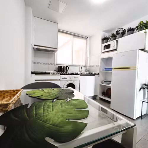 Primer plano de mesa de comedor de cristal con decoración de hojas verdes