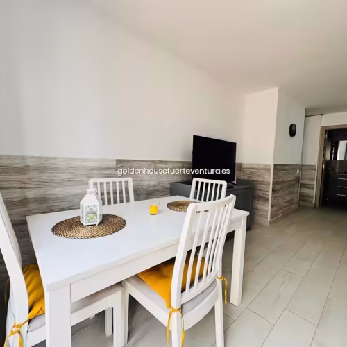 Perspectiva desde el comedor hacia la cocina y el pasillo de la vivienda vacacional.
