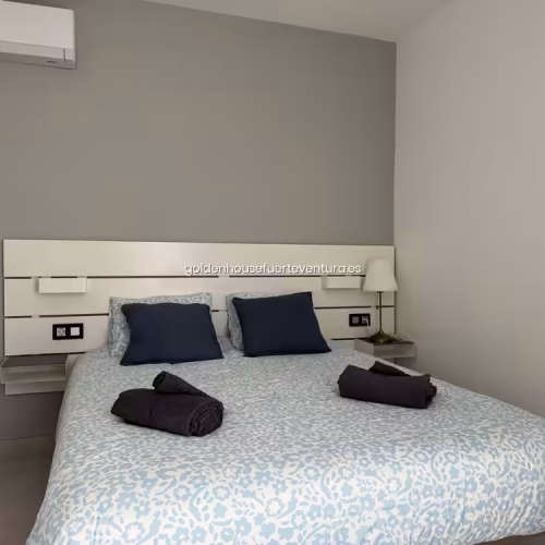 Habitación de matrimonio equipada con split de aire acondicionado sobre la cama.