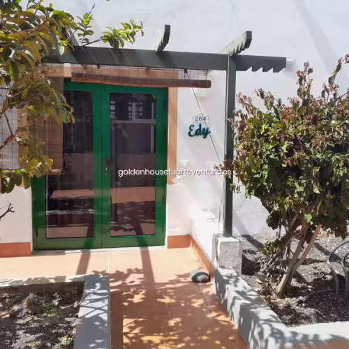 Puerta de entrada verde con placa identificativa del Apartamento Edy en Fuerteventura.