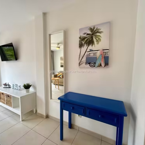 Recibidor con consola azul y espejo vertical en Fuerteventura.
