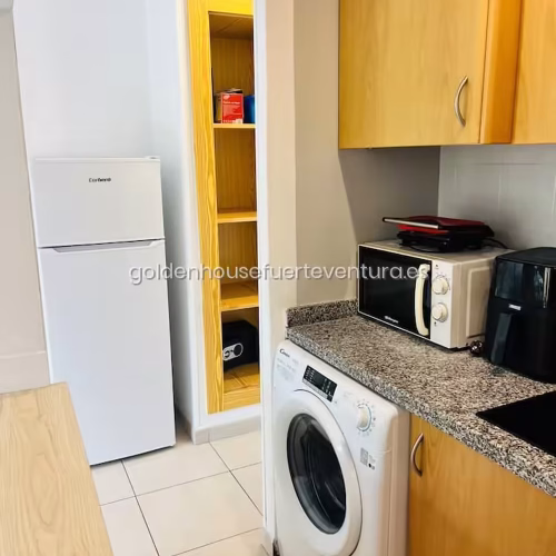Lavadora blanca y nevera en el área de cocina en Fuerteventura.