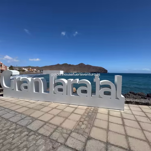 Cartel con letras blancas de Gran Tarajal junto a la costa.