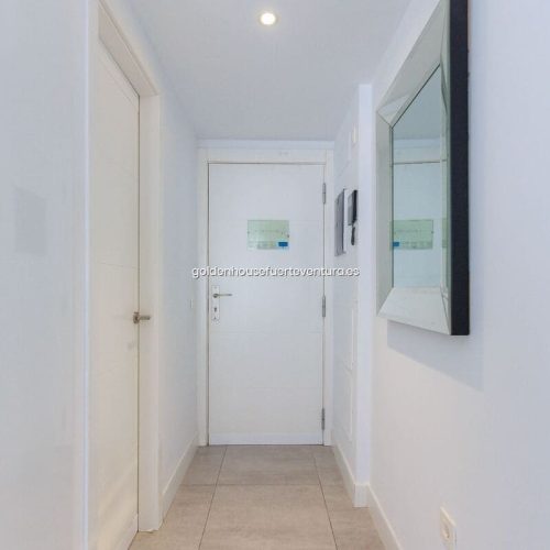 Puerta blanca junto a un espejo colgado de la pared.