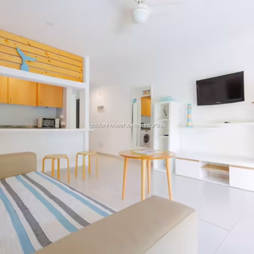 Mueble de televisión blanco con estanterías y decoración de mariposas en la pared.