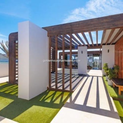 Entrada a un apartamento con una columna blanca.