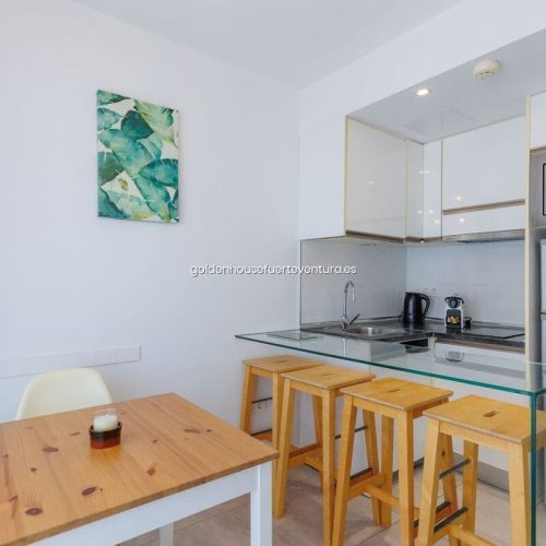 Cocina equipada con microondas y electrodomésticos y un comedor.