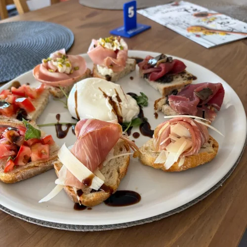 Tostas variadas con embutidos, queso y tomate en Restaurante Atlántico Fuego y Sal