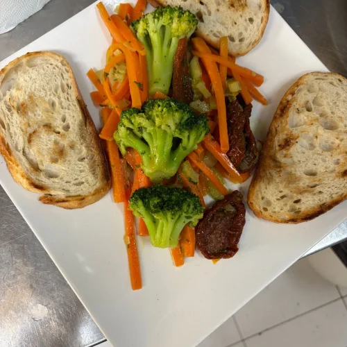 Plato de verduras salteadas con pan tostado en Restaurante Atlántico Fuego y Sal