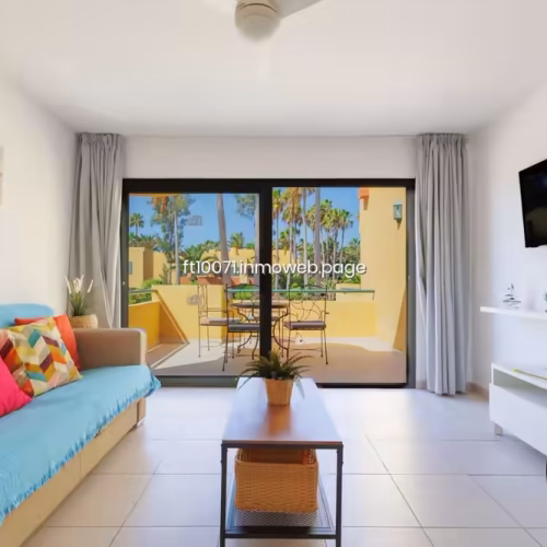 Salón luminoso con sofá y puertas correderas hacia terraza exterior