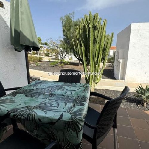 Balcón privado con mesa y sillas exteriores.