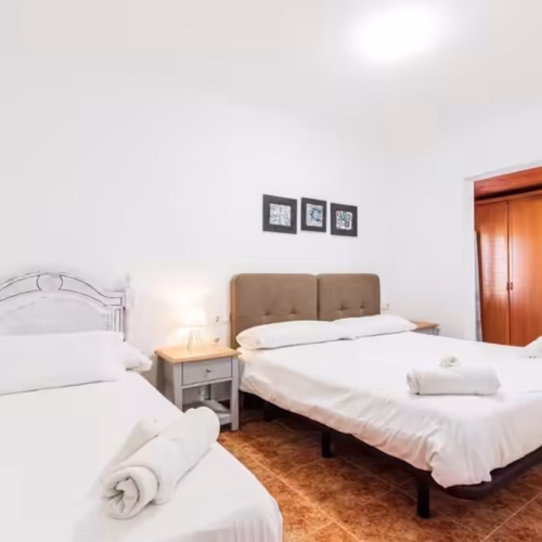 Habitación con una cama de matrimonio y una cama individual con sábanas blancas en Villa Sophia.
