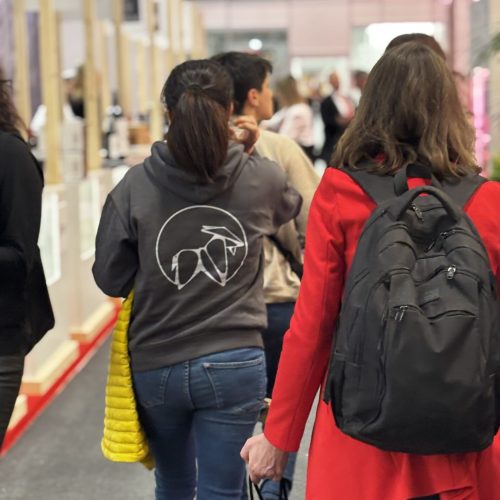 Dos visitantes caminando frente al stand de La Puipana en feria gastronómica