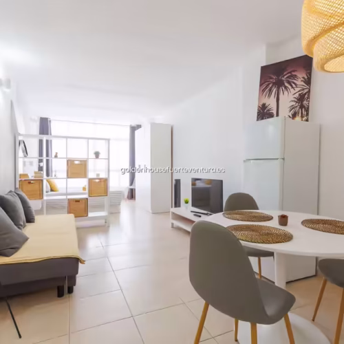 Vista panorámica desde el comedor mostrando salón, dormitorio y cocina al fondo