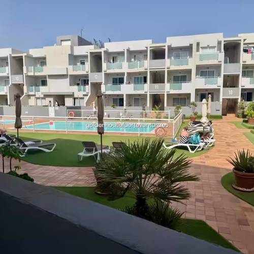 Panorámica de las zonas comunes y la piscina desde una planta superior.