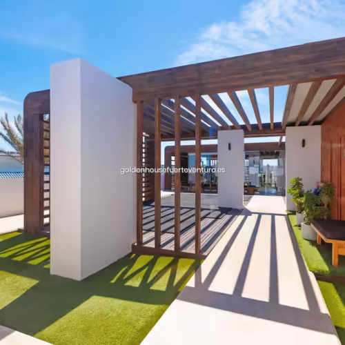 Estructura de pérgola de madera moderna sobre césped artificial en una zona común de descanso.